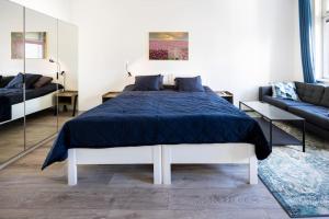 une chambre avec un grand lit et un canapé dans l'établissement Royal Blue Deluxe, à Vienne