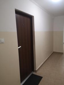 a brown door in a room with a tile floor at Małe mieszkanie in Łomża