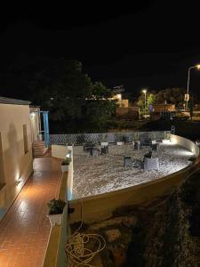 eine Terrasse in der Nacht mit einer Gruppe von Tischen und Bänken in der Unterkunft Il Guernico appartamenti in Volterra