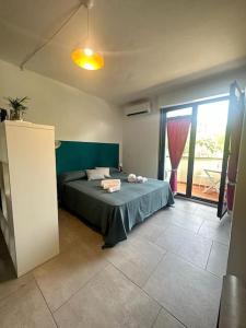 ein Schlafzimmer mit einem Bett und einem großen Fenster in der Unterkunft Il Guernico appartamenti in Volterra