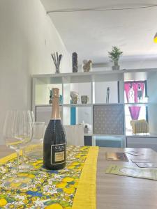 een fles wijn zittend op een tafel met een glas bij Il Guernico appartamenti in Volterra