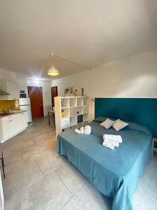 um quarto com uma cama azul com toalhas em Il Guernico appartamenti em Volterra