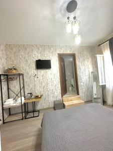 ein Schlafzimmer mit einem Bett und einem Fernseher an der Wand in der Unterkunft Guest House "Mtisubani" in Sighnaghi