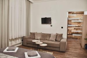 een woonkamer met een bank en 2 tafels bij Apartment in Belgrade with small parking space in Belgrado