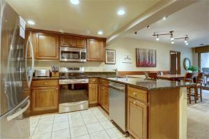 a large kitchen with wooden cabinets and a counter top at Cm336 Copper Mtn Inn Condo in Copper Mountain