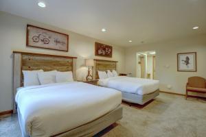 a hotel room with two beds and a chair at Cm336 Copper Mtn Inn Condo in Copper Mountain