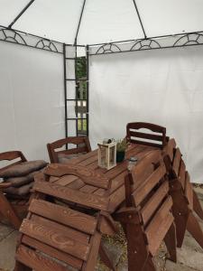 a wooden table and chairs under a tent at Letniskowy Domek Berneński Zakątek in Charzykowy