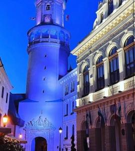 a lighthouse is lit up in front of a building at Sicomoro Casa in Sopron