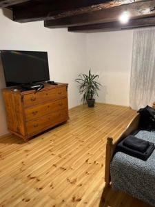 uma sala de estar com televisão numa cómoda de madeira em Puskás vendégház 