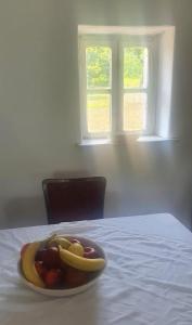 um prato de fruta numa mesa com uma janela em Puskás vendégház 