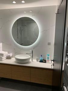 a bathroom with a sink and a mirror at Above & Beyond Volos City Center Luxury Redefined in Volos