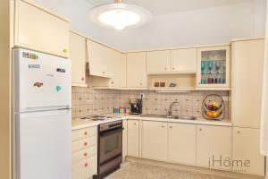 uma cozinha com armários brancos e um frigorífico branco em I Love Samos - Maisonette at the heart of Pythagorio em Pythagoreio