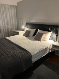 a bedroom with a large bed with white sheets and pillows at Apartman Loft 72 in Slavonski Brod