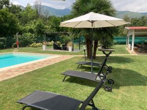 una mesa y una sombrilla junto a una piscina en CasaD, en San Gillio