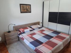 a bedroom with a bed with a checkered blanket at Rooftop terrace appartment in Skopje