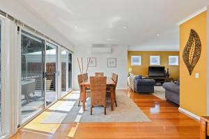 a living room with a table and a couch at The Tides by Ready Set Stay - BYO LINEN & TOWELS in Cowes