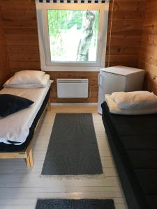 a small room with two beds and a window at Arctic Camping Finland in Pello