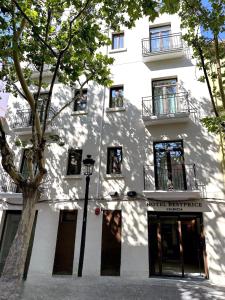 ein weißes Gebäude mit einem Baum davor in der Unterkunft Hotel BESTPRICE Valencia in Valencia