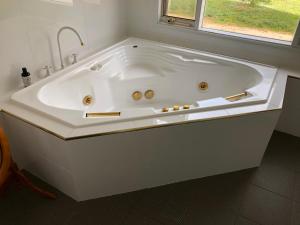 a large white bath tub in a bathroom with a window at Clare to Spalding character escape in Spalding