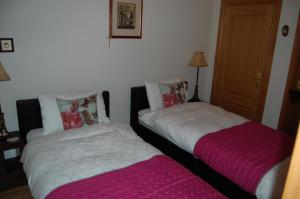 dos camas sentadas una al lado de la otra en una habitación en Lomond Castle Apartment, en Balloch