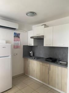 a kitchen with white cabinets and a white refrigerator at Apartment Mare in Cunski