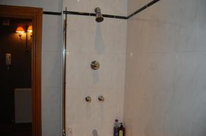 a shower in a bathroom with white tile at Lomond Castle Apartment in Balloch