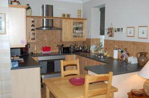 cocina con encimera, mesa y sillas en Lomond Castle Apartment, en Balloch