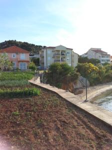 a walkway next to a river with buildings in the background at Apartments Lukacic in Tkon
