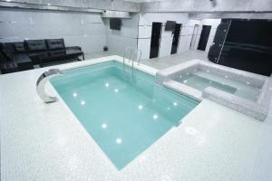 una gran piscina en una habitación con sofá en Regal Hotel by Grand, en Navoi