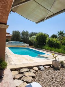 a swimming pool in a yard with a patio at La Toscane in Roquebrune-sur-Argens