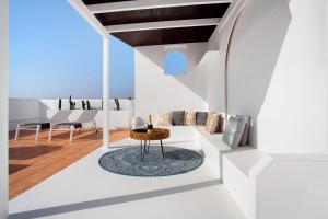 a living room with white walls and a table at Luxury Ocean View - Carpe Mundi in Corralejo