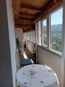 una mesa y sillas en una habitación con ventanas en Cozy Loft with Fireplace & View, en Metsovo