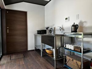 a kitchen with stainless steel appliances and a wooden door at 游月庵 in Inuyama