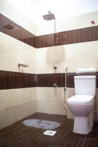 een badkamer met een toilet en een douche bij FAHARI .KE 3BR BY MTWAPA HOMESTAY in Mombasa