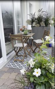 een patio met een tafel, 2 stoelen en bloemen bij Ferienwohnung in Maikammer in Maikammer