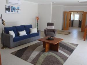 uma sala de estar com um sofá azul e uma mesa de centro em Villa with private wellness and pool em Salir de Matos