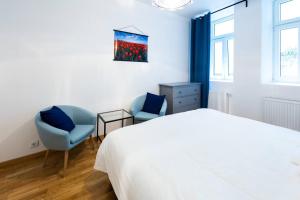 um quarto branco com 2 cadeiras e uma cama em Simply Serene em Viena