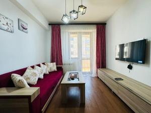 un soggiorno con divano rosso e TV di Apartments by GR Yerevan in the city centre a Yerevan