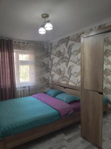 ein Schlafzimmer mit einem Bett und einer Wand mit Walen in der Unterkunft Мейкин in Osch
