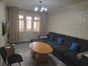 uma sala de estar com um sofá e uma mesa em Мейкин em Osh