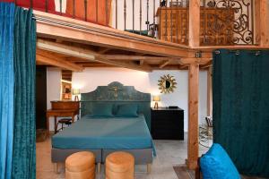 Schlafzimmer mit einem Bett mit blauer Tagesdecke in der Unterkunft The workshop - Atypical loft private swimming pool & garden 3 stars in Aubais