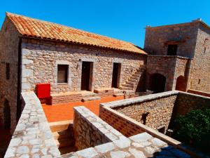 an old stone building with a red chair in it at Pirgoi Edem in Pyrgos Dirou
