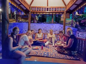 a group of people sitting on a couch at Asim Paris Guesthouse & jungle trekking in Bukit Lawang