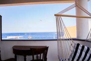 a hammock in a room with a view of the ocean at Casa Lussu in Lipari
