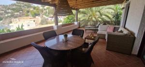a table and chairs on a balcony with a view at Los Cipreses - Casa Ola in Almuñécar