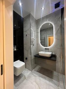 a bathroom with a sink and a mirror at Levent beach 1,Luxury apartment in Sumqayyt