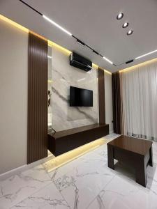Levent beach 1,Luxury apartment في سومقاييت: غرفة معيشة مع تلفزيون على الحائط