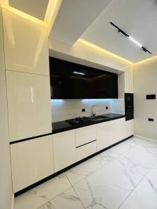 uma grande cozinha com armários brancos e um lavatório em Levent beach 1,Luxury apartment em Sumqayıt