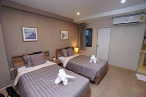 a hotel room with two beds with white towels on them at Maruay Living Apartment 509 (Khaosan/Chinatown/Samyot MRT) in Bangkok