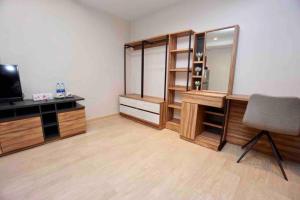 a room with a desk and a chair and a television at Maruay Living Apartment 509 (Khaosan/Chinatown/Samyot MRT) in Bangkok